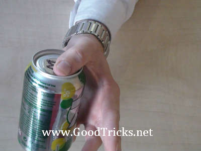 Coin is secretly slid onto top of can.