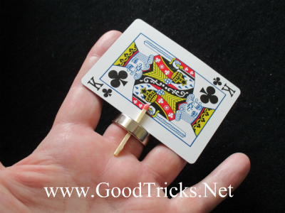 Image showing playing card being held in place between the matchstick and the magician's finger.