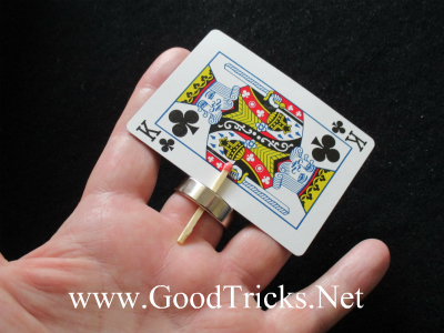 Image of ring and a match holding a card in place under a hand ready to do a magic trick.