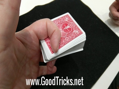 Deck is shown held firmly between first and second curled fingers.