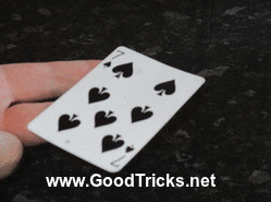 Playing card is seen freely spinning in the magician's hand.