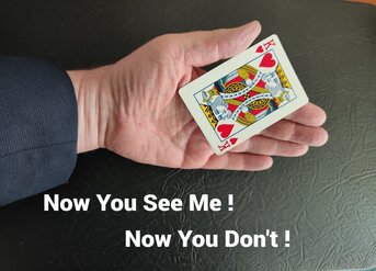 Magician demonstrating card vanishing in his hand.