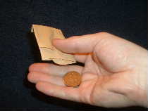 Turn pouch upside down and allow the coin to fall into the palm of your hand.