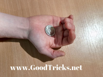 Fingers curl in to palm to allow the coin to fall into position..