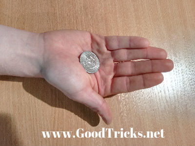 Coin is seen here, held in palm position.
