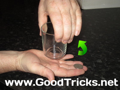 Image showing coin in new position near finger tips, raedy to be thrown up into the glass.