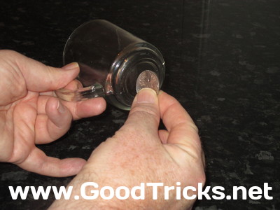 Image showing coin being tapped on base of glass to prove that it is solid.