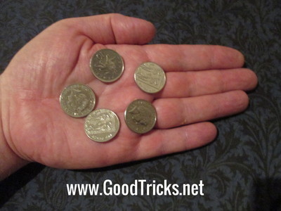 Five coins placed in palm of spectator's hand for finale of magic coin trick.