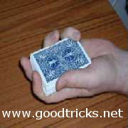 Hold deck in left hand, fingertips resting on top right edge, base of thumb resting on bottom left edge of pack.