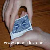 Turn up one edge of the top two cards with the thumb of your right hand.
