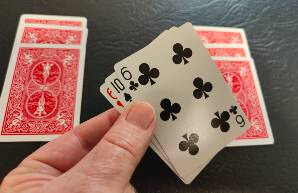 One pile is lifted and the bottom card is memorized.