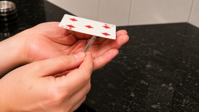 Playing card seems to be rising up in the air.