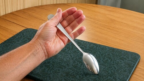 Coin is place directly above the spoon handle.