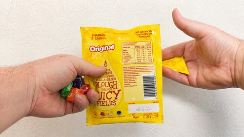 Candies and packet corner concealed in the hand