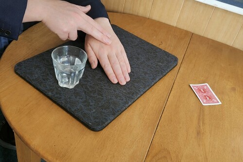 Magician secretly applying a small amount of water to the back of the hand
