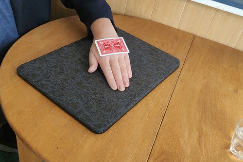 Playing card beginning to bend while resting on the back of the hand