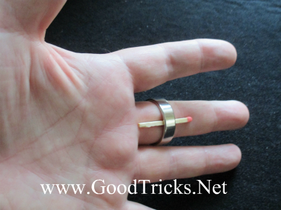 Image showing matchstick inserted under finger ring on the card magician's hand.