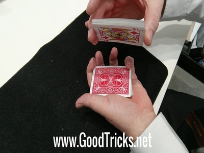 Pack of cards is split in two and held open for spectator to place back their secret card. Note the pinky break on the top right of the photo.