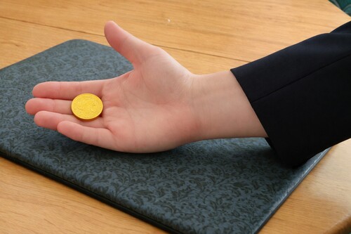 Coin resting across the middle fingers ready for Finger Palm