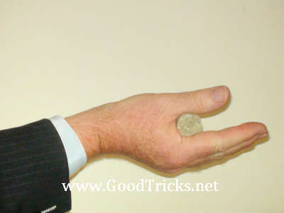 Hold coin in between fleshy part of thumb and first finger