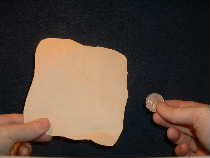 Obtain paper square and coin to perform this close up magic trick.