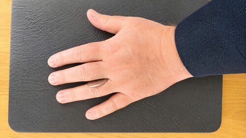 Duplicate coin secretly positioned between the middle fingers