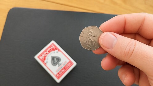 Spectator examining the coin that apparently passed through the deck