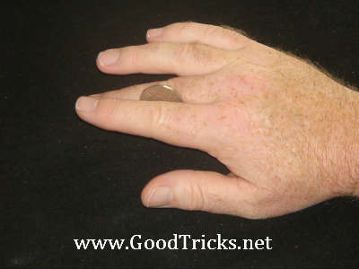 First finger is lifted up slightly to assist in flipping coin over onto second finger.