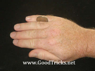 Coin is held in place between finger and pinky as shown here.
