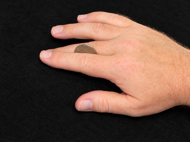 Coin rolling across fingers.