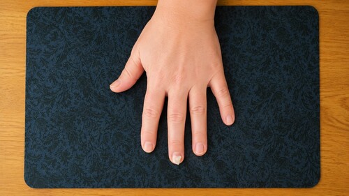 A small piece of double-sided tape placed on a fingernail