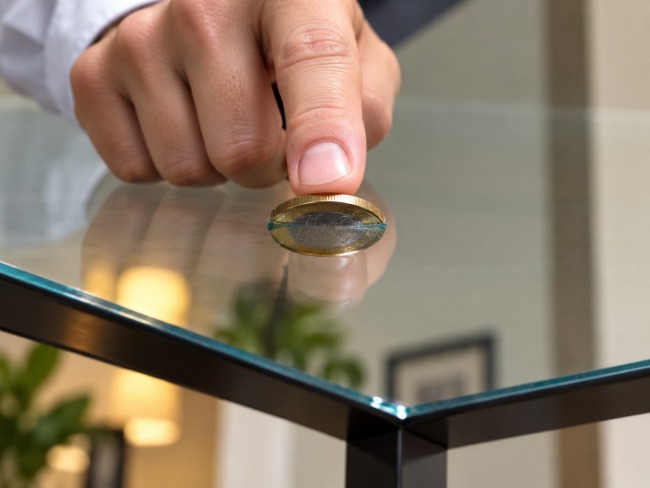 Coin appears to be pushed through a glass table..