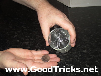 Image showing coin being swirled in glass and tipped out for examination by the audience.
