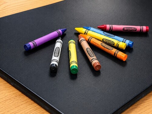 Different coloured crayons arranged on a table