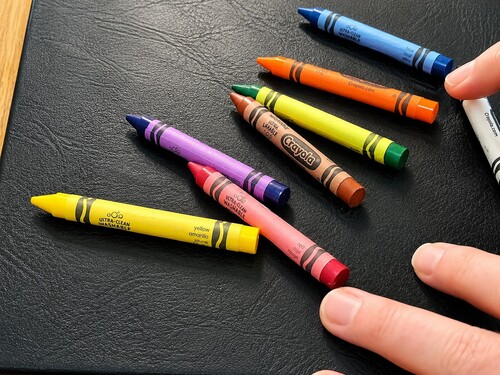 The selected crayon being mixed back among the other crayons