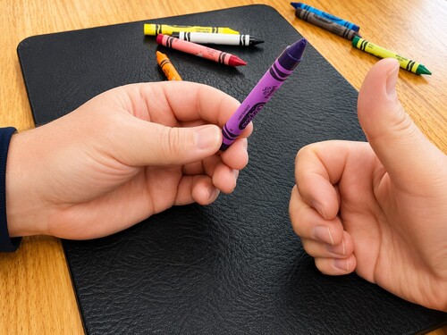 The magician revealing the spectator's secretly chosen crayon colour