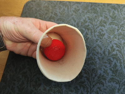 Thumb is pushed through flap to hold the ball in place.