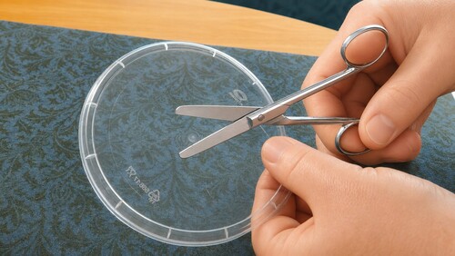 Cutting out disc from plastic packaging.