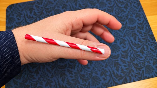 Short straw taped to the back of a thumb