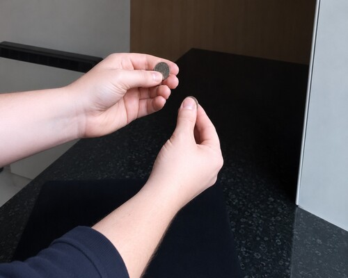 The two larger coins separated while the small coin is concealed in finger palm