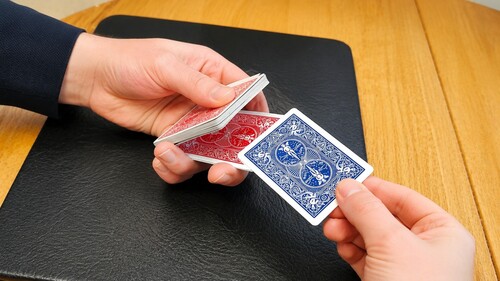 A spectator returning a chosen playing card between two halves of the deck