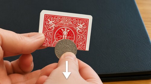Coin being pulled downward through the small hole in the card