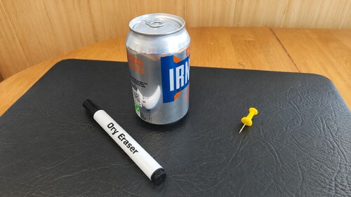 Soda can, safety thumb tack and dryboard marker used for the trick