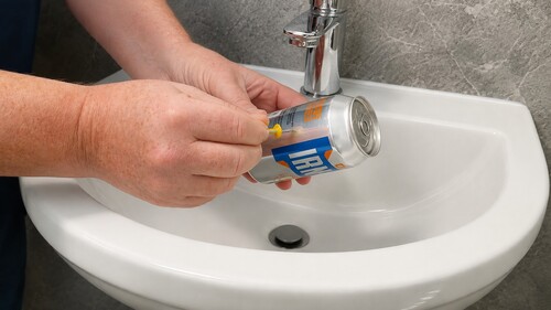 Small hole being made in the side of the soda can