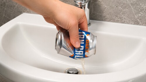 Soda being poured out through a small hole in the side of the can