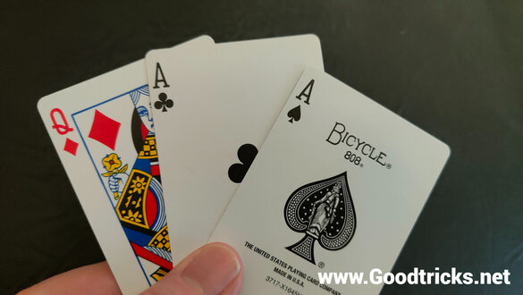 Three playing cards fanned out in hand to allow the magician to choose the correct card.