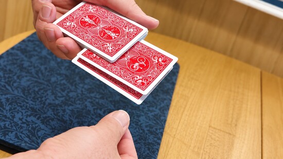 Playing cards being inserted into deck.