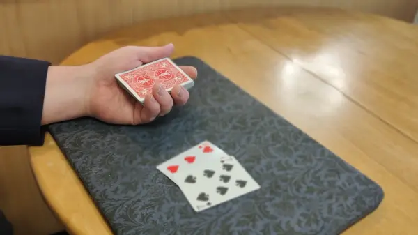 The second pair of cards being placed on top of the deck