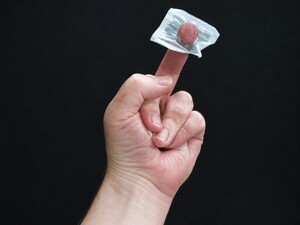 Finger apparently penetrating a sugar packet