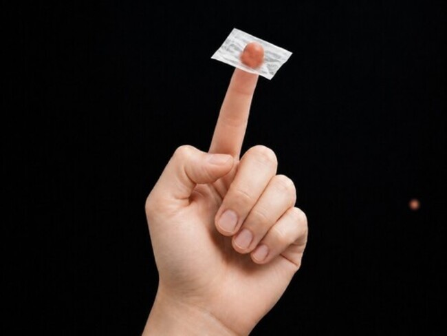 A finger is pushed right through a sugar packet.